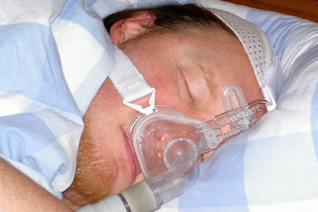Homme endormi portant un masque de ventilation par pression positive continue