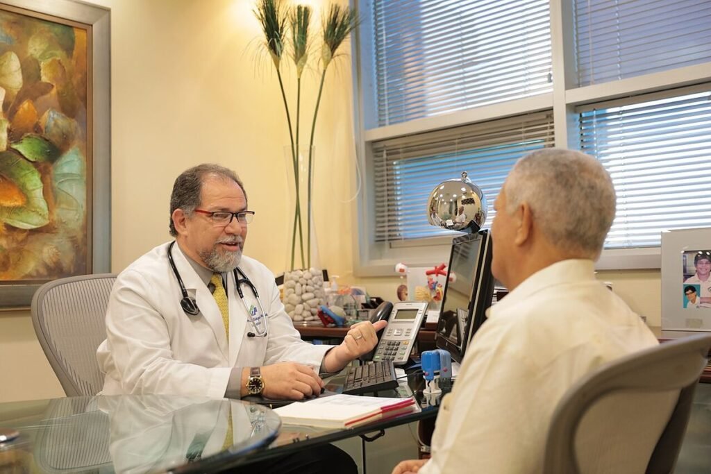 Médecin en blouse blanche échangeant avec un patient âgé dans son cabinet