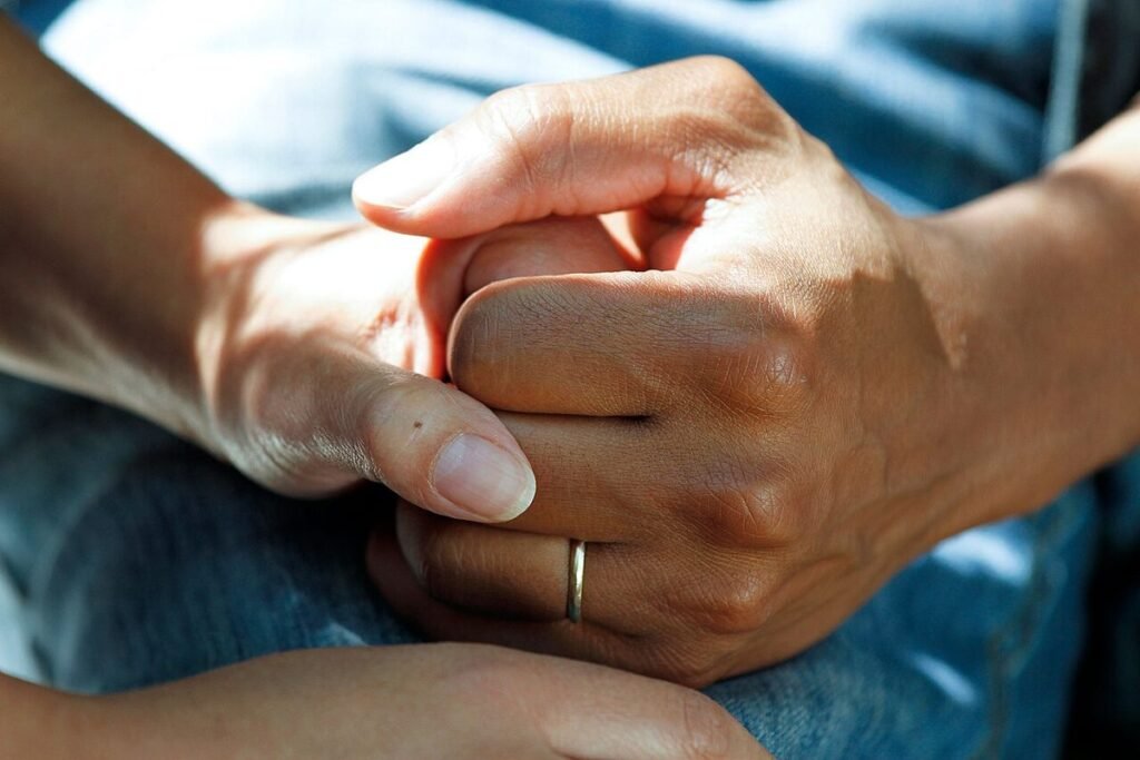Mains d'un couple enlacées, alliance au doigt