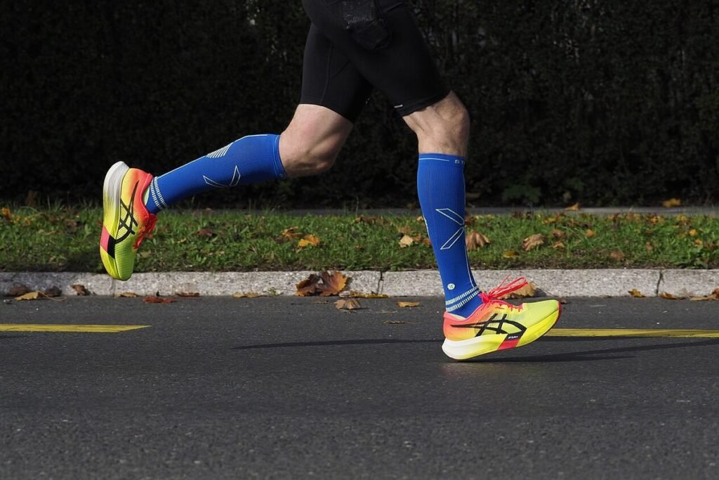 Jambes d'un coureur en pleine foulée sur l'asphalte